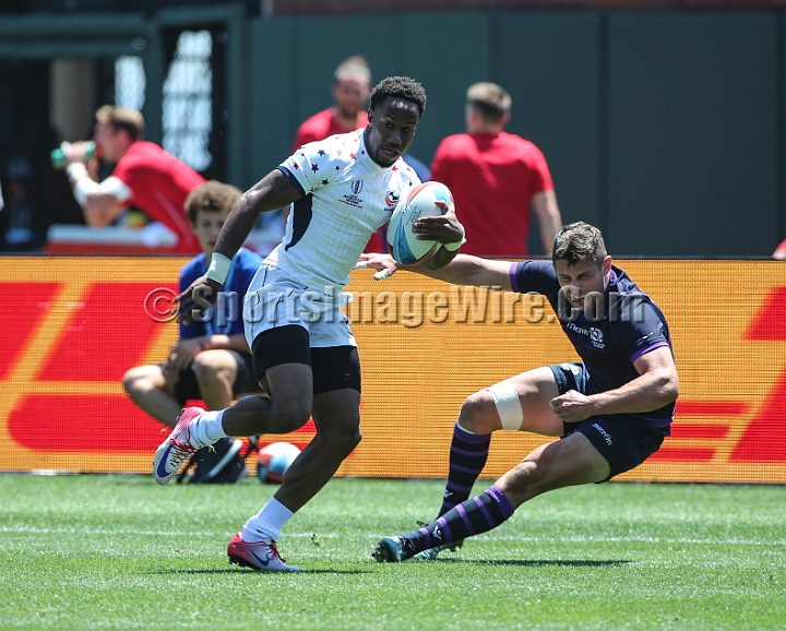 2018RugbySevensSun-05.JPG - United States player Carlin Isles eludes Scotland player Robbie Furgusson (4) to score a try in the men's championship 5/8 place match of the 2018 Rugby World Cup Sevens, Sunday, July 22, 2018, at AT&T Park, San Francisco. USA defeated Scotland 28-0. (Spencer Allen/IOS via AP)